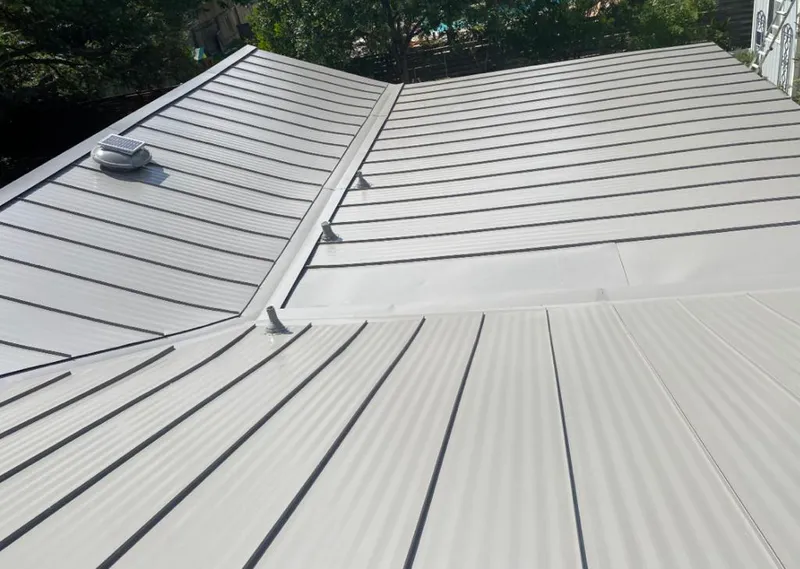 Solar attic fan installed on a metal roof for Roof Ventilation in Forest